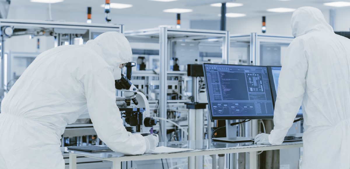 scientists looking through microscope in life sciences cleanroom