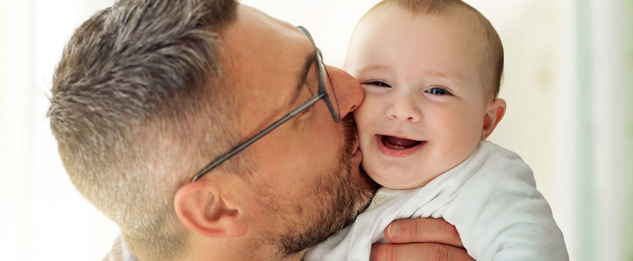 father kissing his baby