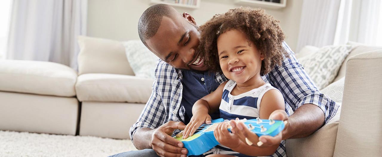 father playing guitar with his daughter