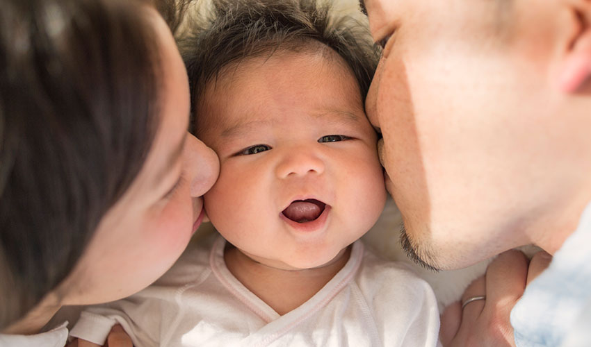 happy family kisses baby