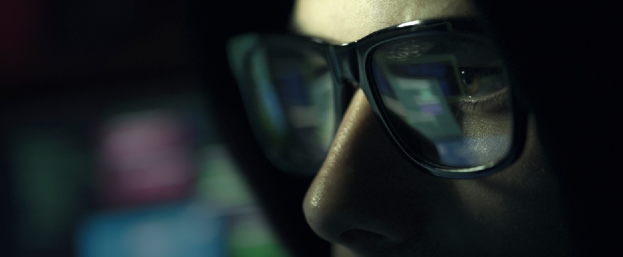 man wearing glasses closeup dark background