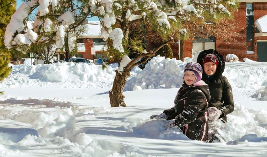 mom and child play in the snow