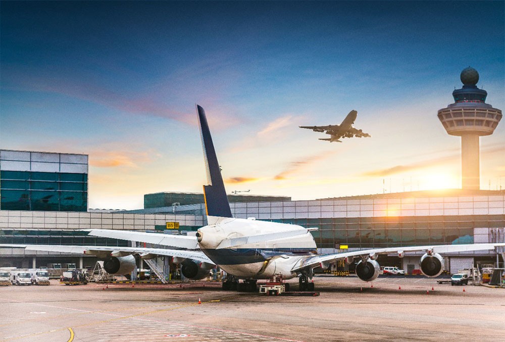 un avion au sol et un avion qui décolle en face d'un aéroport